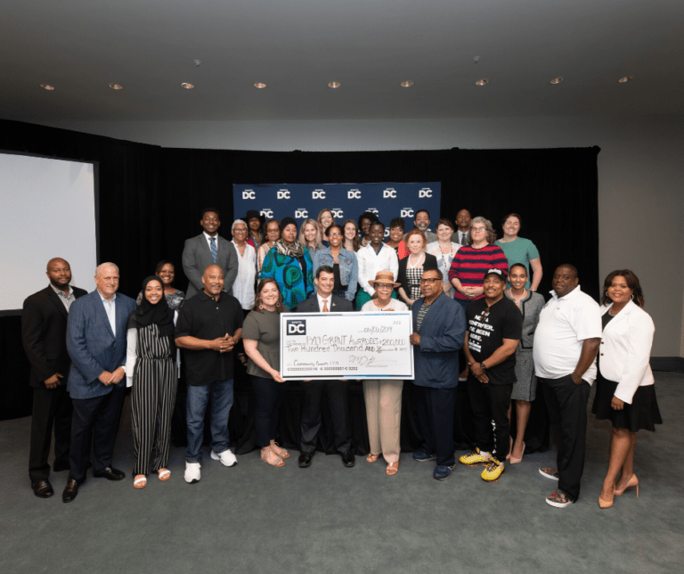 Group posing with check