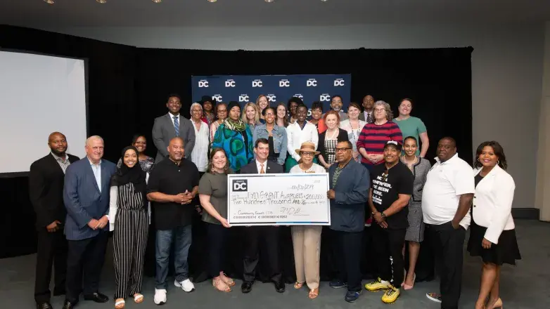 Group posing in with check