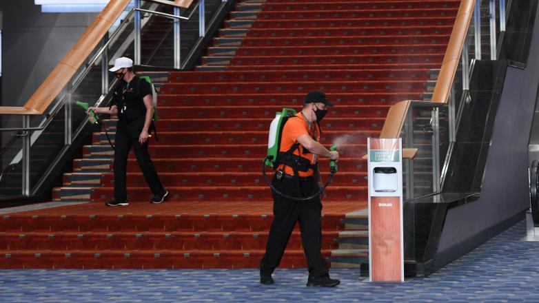 Electrostatic sprayers in use on stair handrail